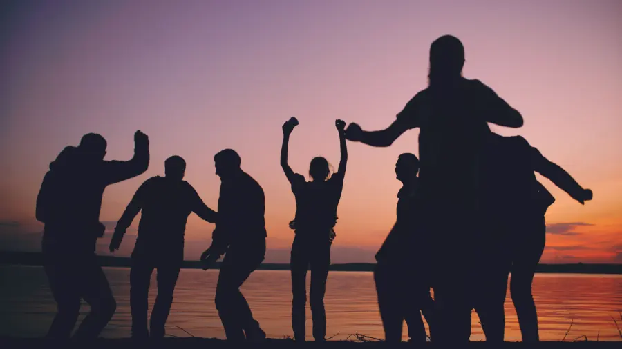 Grupo de personas bailando al aire libre al atardecer